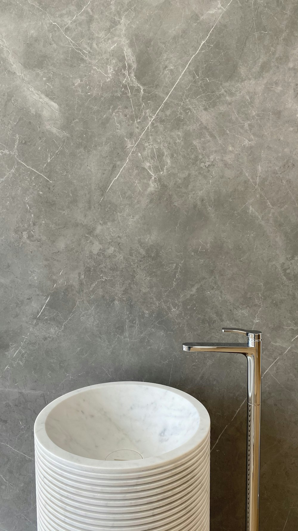 stainless steel faucet on gray concrete wall