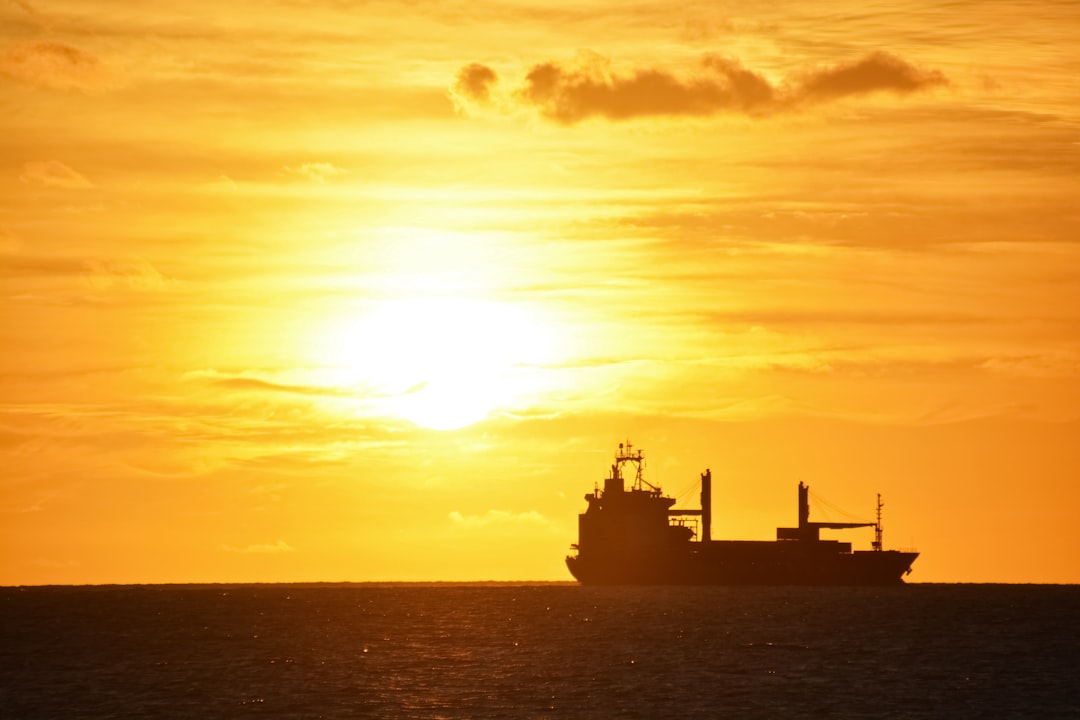 silhouette of ship on sea during sunset