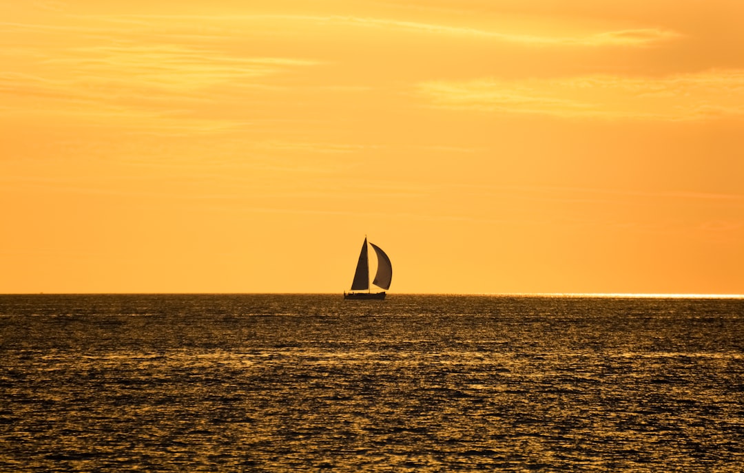 sailboat on sea during sunset