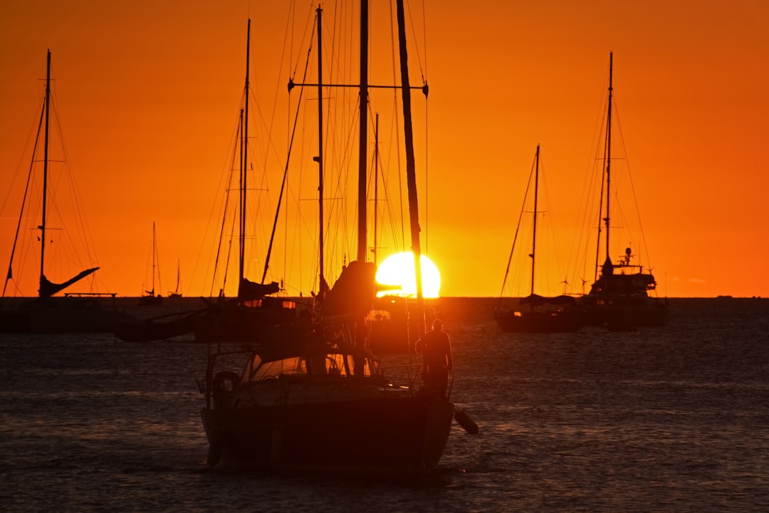 silhouette of boat on sea during sunset