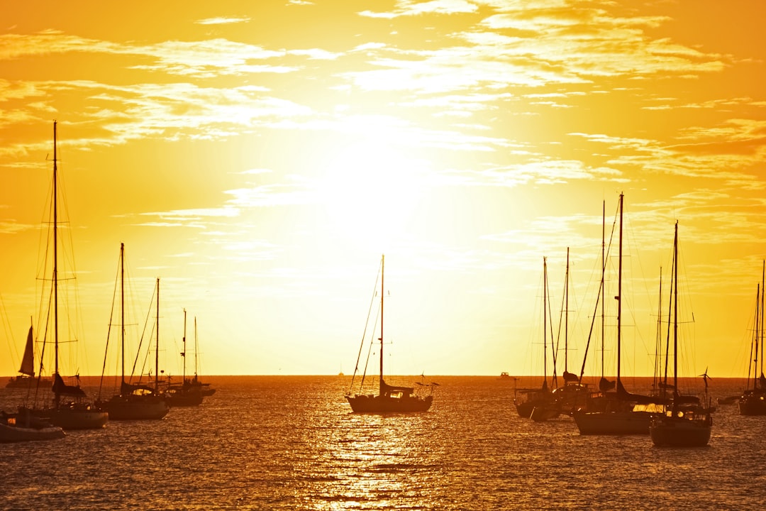 silhouette of sail boat on sea during sunset