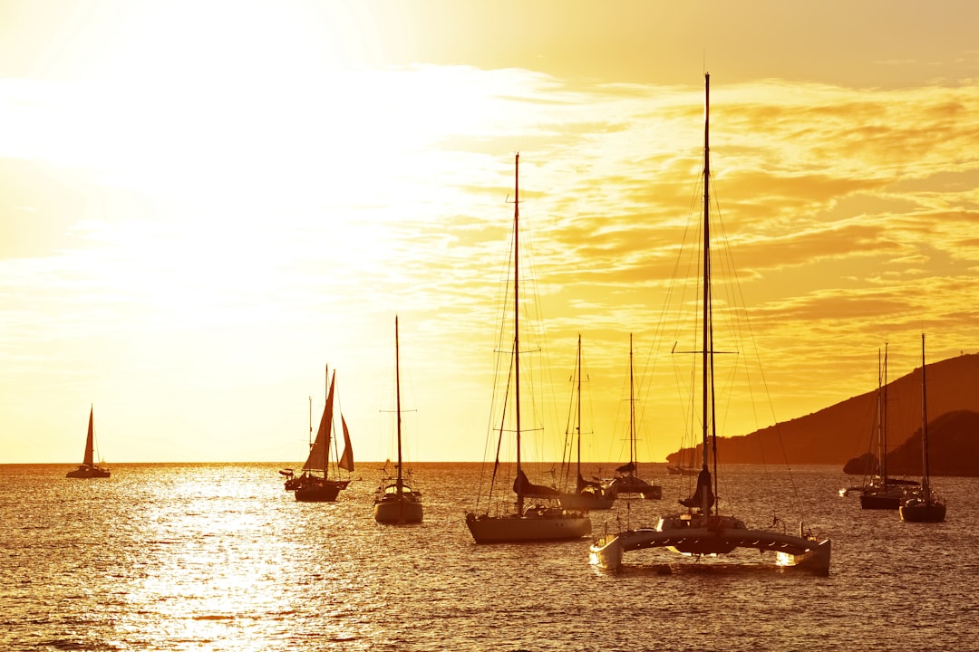 silhouette of sail boat on sea during sunset