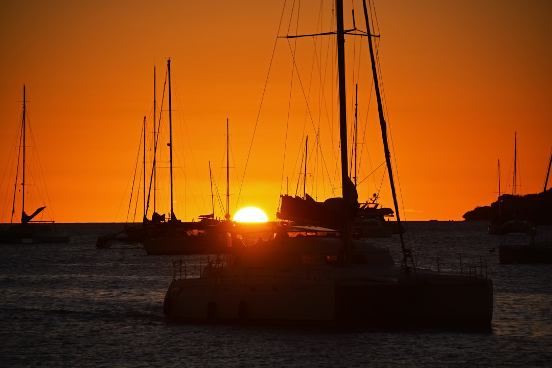 silhouette of boat on sea during sunset