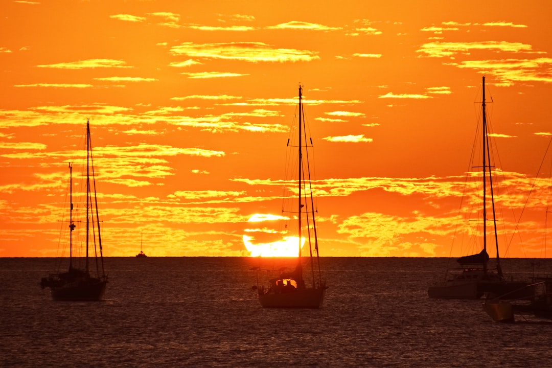 silhouette of boat on sea during sunset