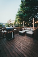 black gas grill on brown wooden deck