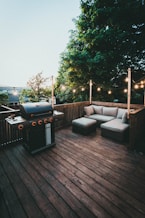 black gas grill on brown wooden deck