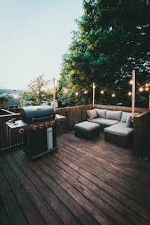 black gas grill on brown wooden deck