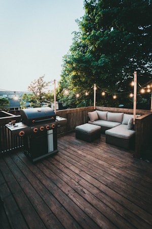 Black gas grill on a wooden deck