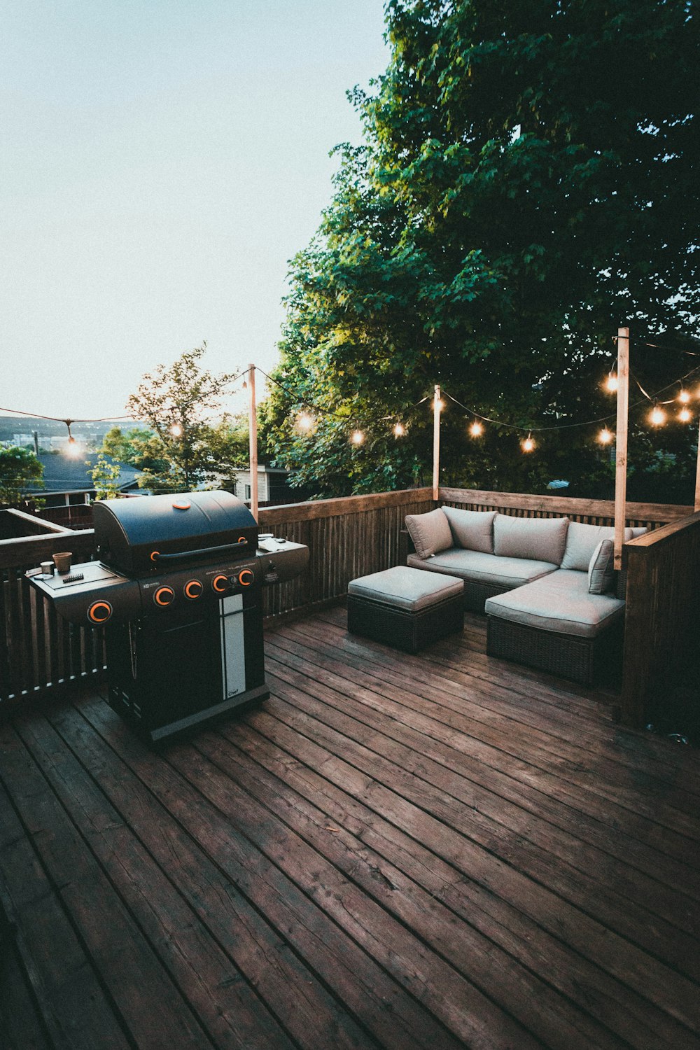 black gas grill on brown wooden deck