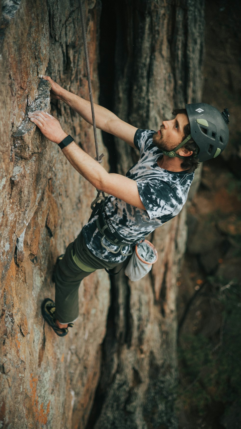 man in black helmet climbing on brown tree during daytime