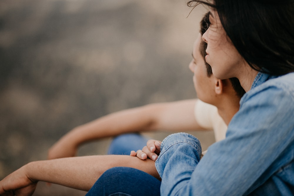 woman in white tank top and blue denim shorts sitting on ground