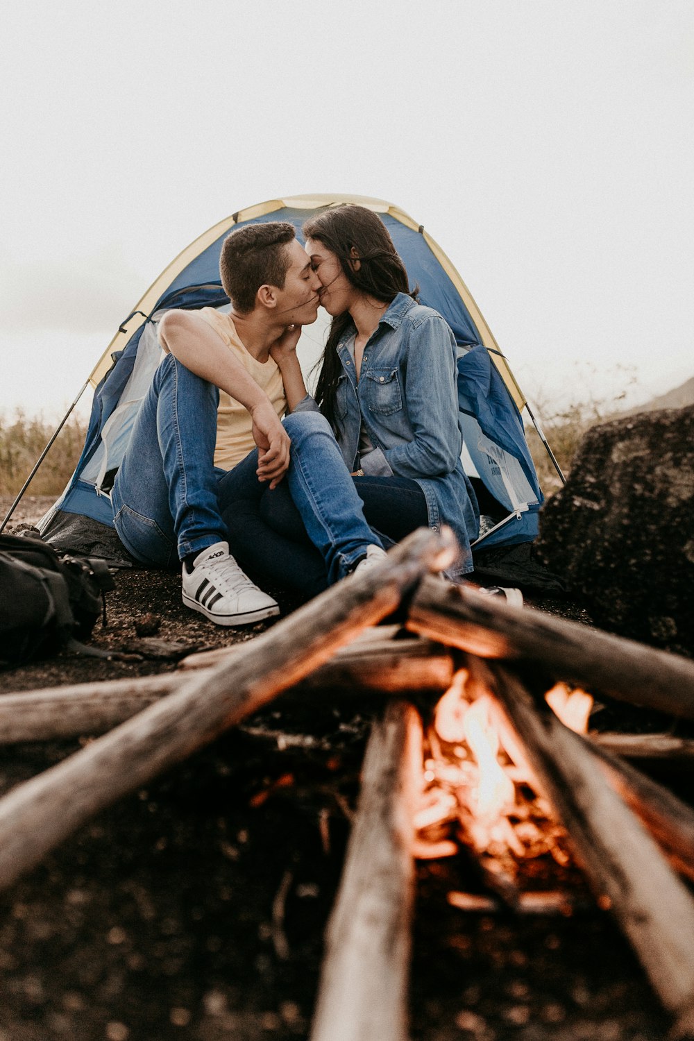 woman in blue denim jacket sitting on tent