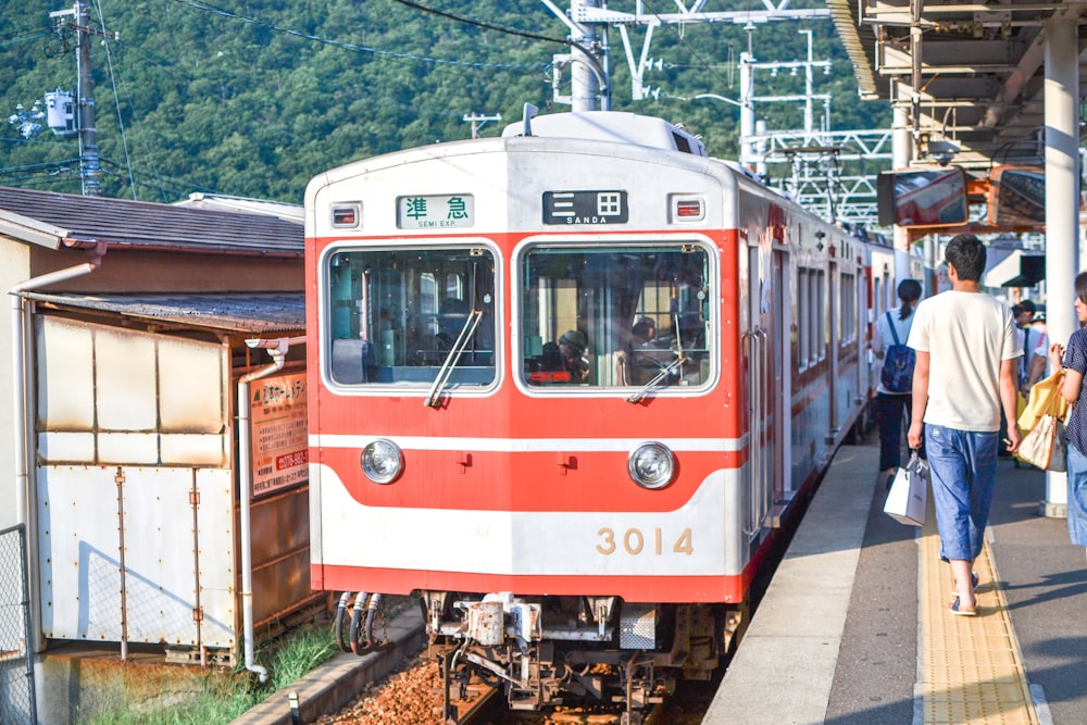 white and red train on rail tracks during daytime