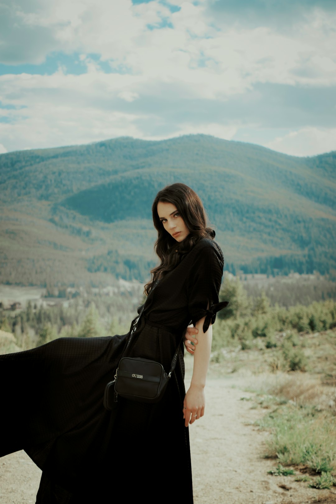 woman in black long sleeve shirt and black pants with black sling bag