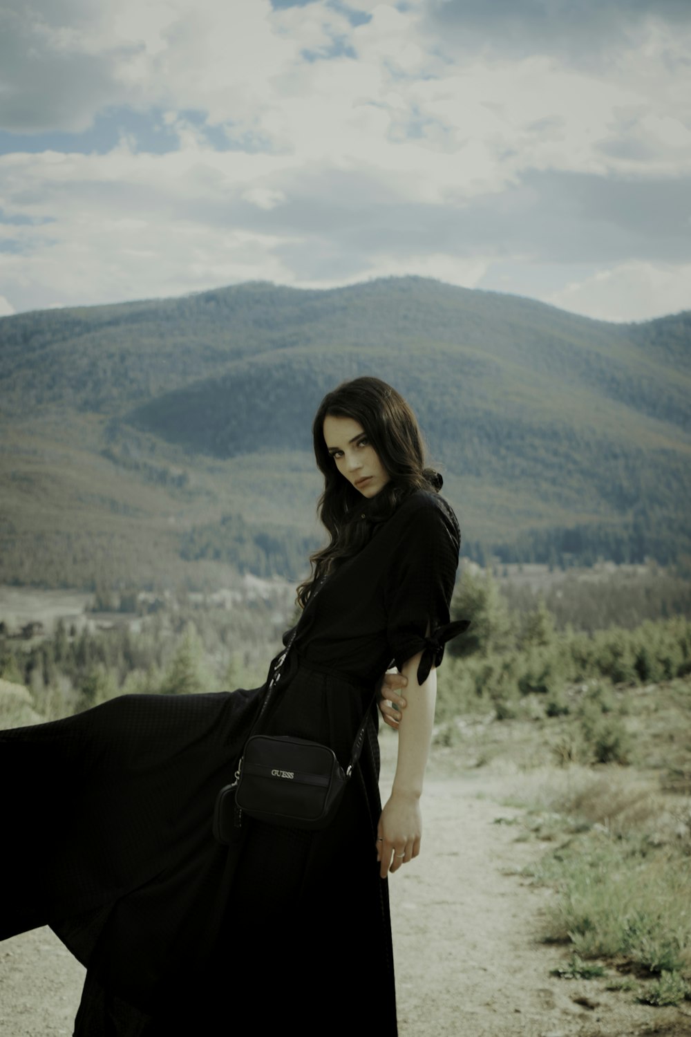 woman in black long sleeve shirt and black pants with black sling bag
