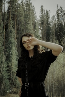 woman in black t-shirt standing in forest