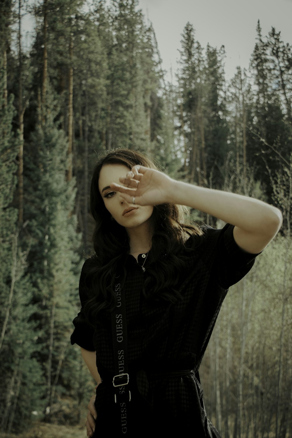 woman in black t-shirt standing in forest