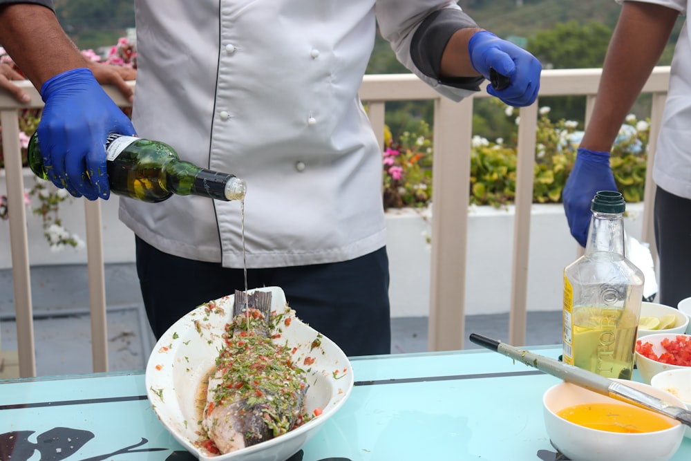 person in white dress shirt holding blue and white ceramic bowl with food