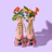 A pair of pink roller skates adorned with vibrant flowers emerging from the tops. The flowers are red, orange, and yellow with green leaves. The wheels of the skates are translucent and pink, set against a light purple background.