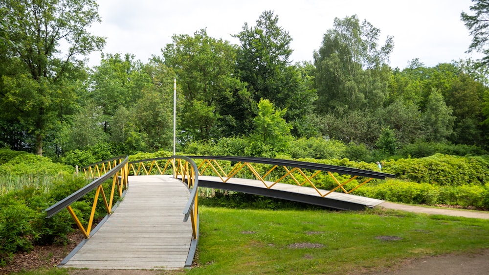 brown wooden bridge over green grass field