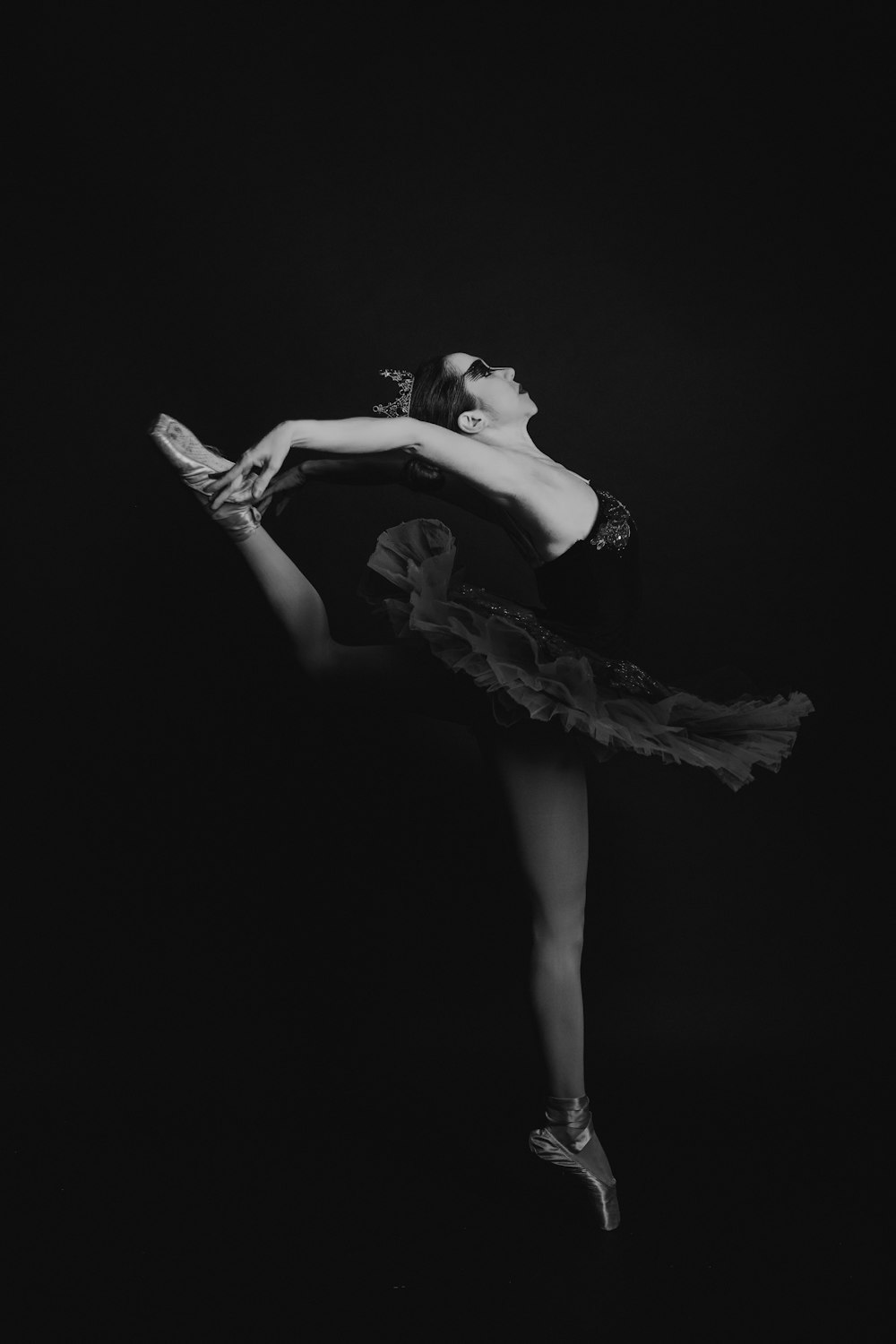 woman in black dress lying on black surface