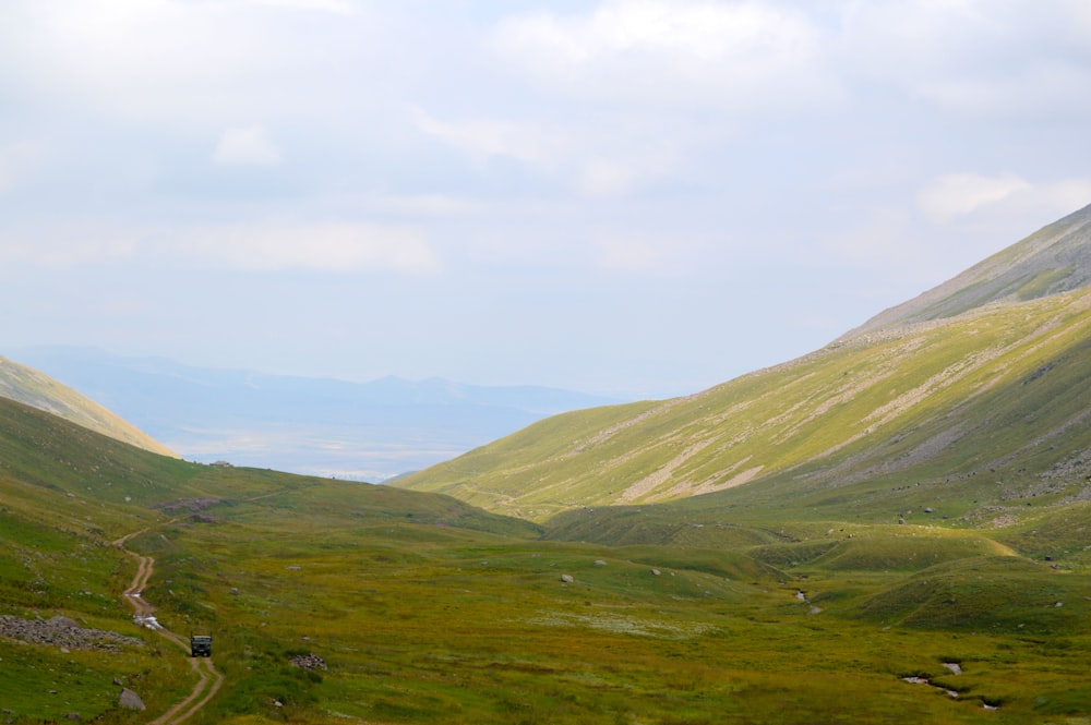 Grüne Berge tagsüber unter weißem Himmel