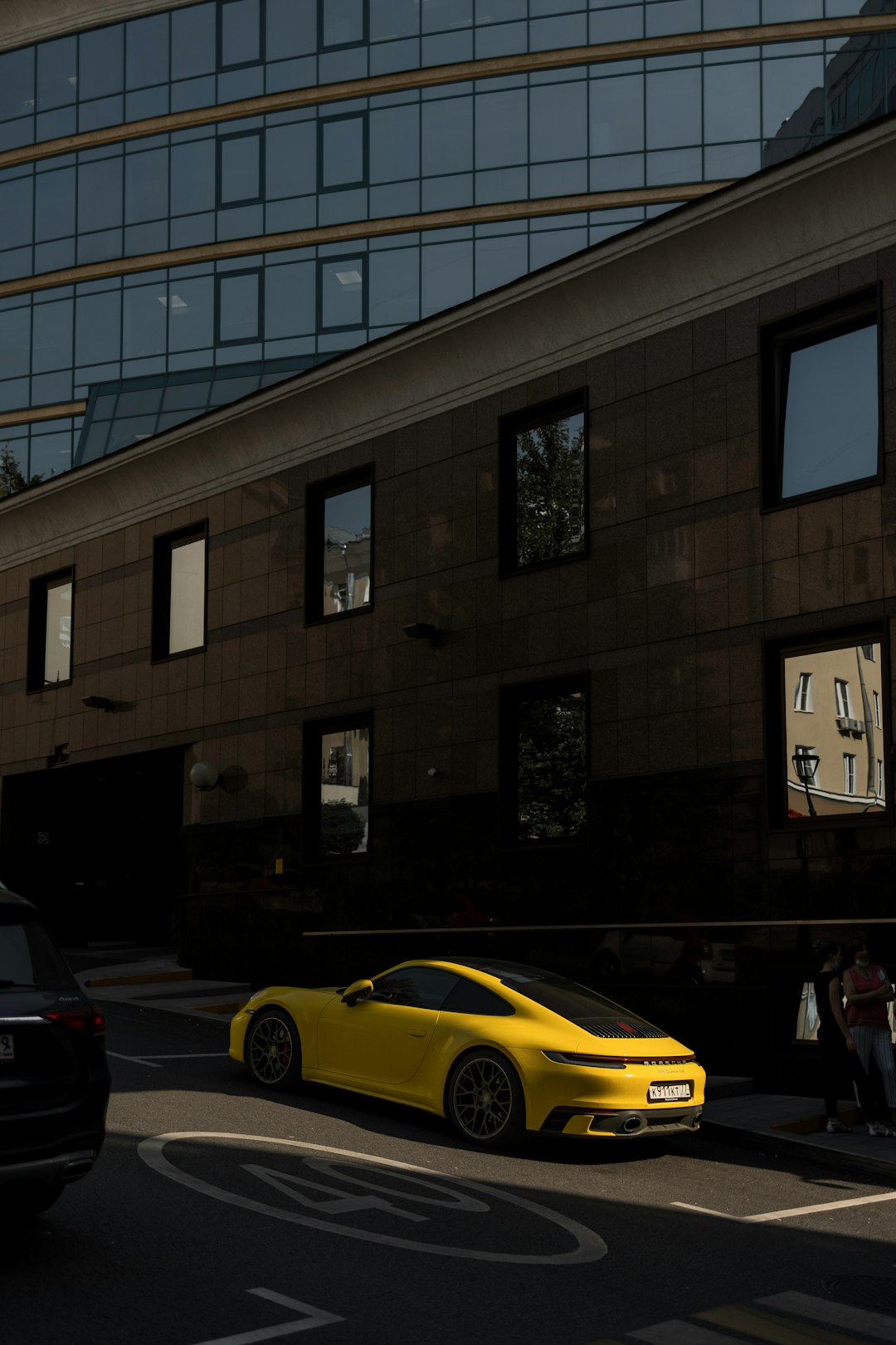 yellow car parked in front of brown building