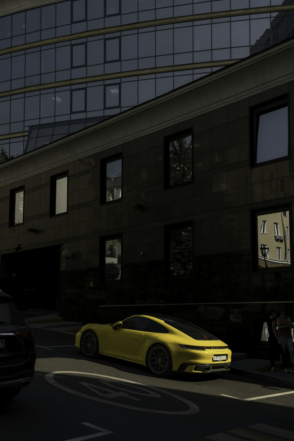yellow car parked in front of brown building