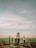 A group of farmers working together in a lush green field under a clear blue sky.