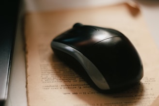 black cordless computer mouse on white paper