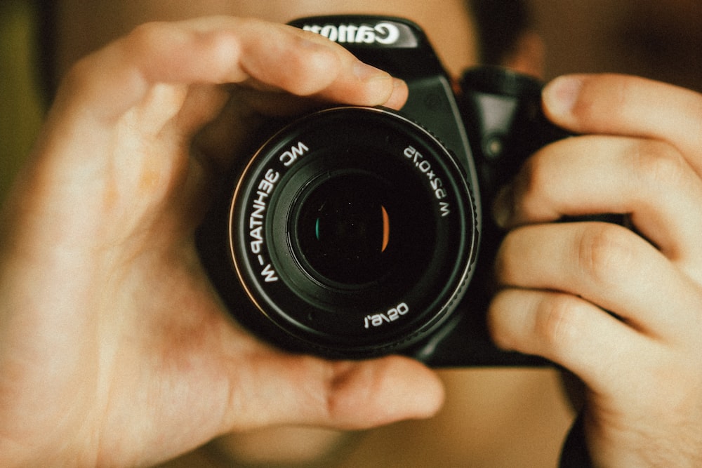 black nikon dslr camera on persons hand