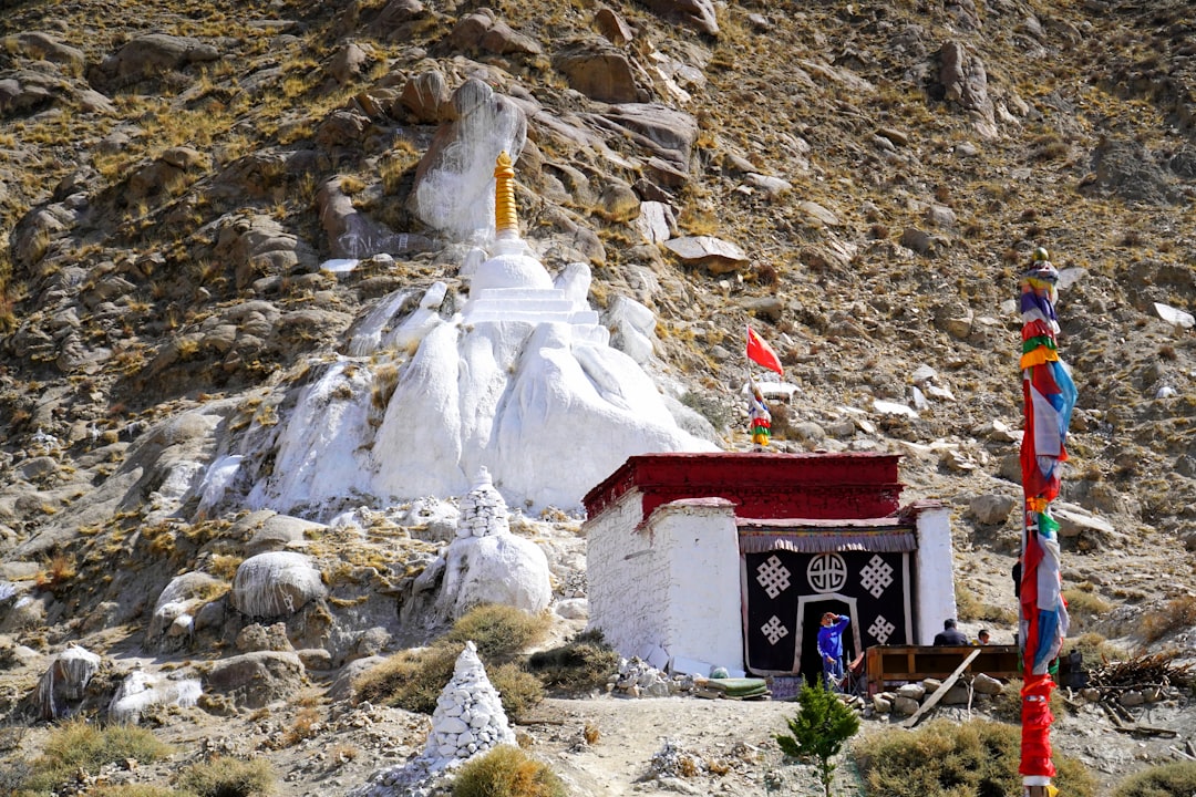 red and white concrete building near gray rocky mountain during daytime