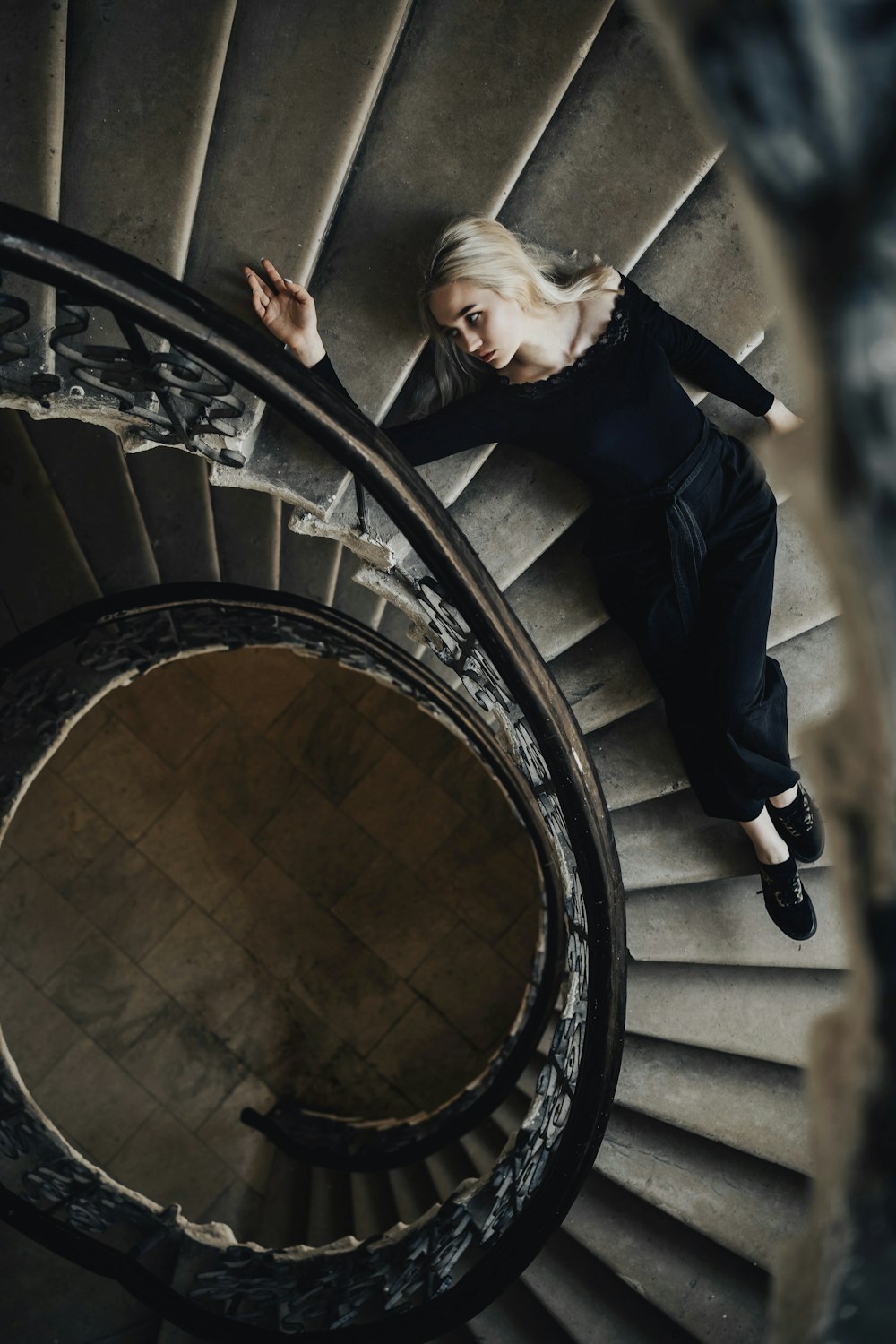 man in black jacket climbing on spiral staircase