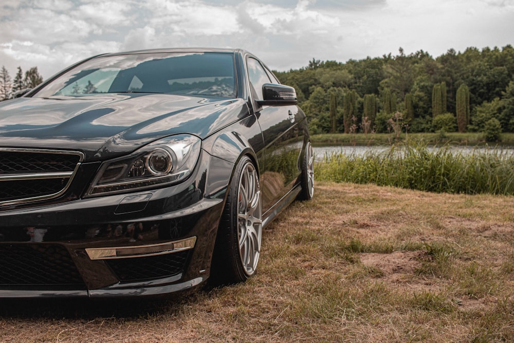 black mercedes benz coupe on green grass field during daytime