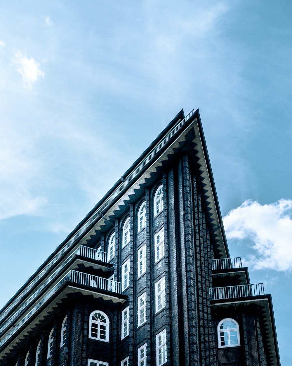 black and white concrete building under white clouds during daytime