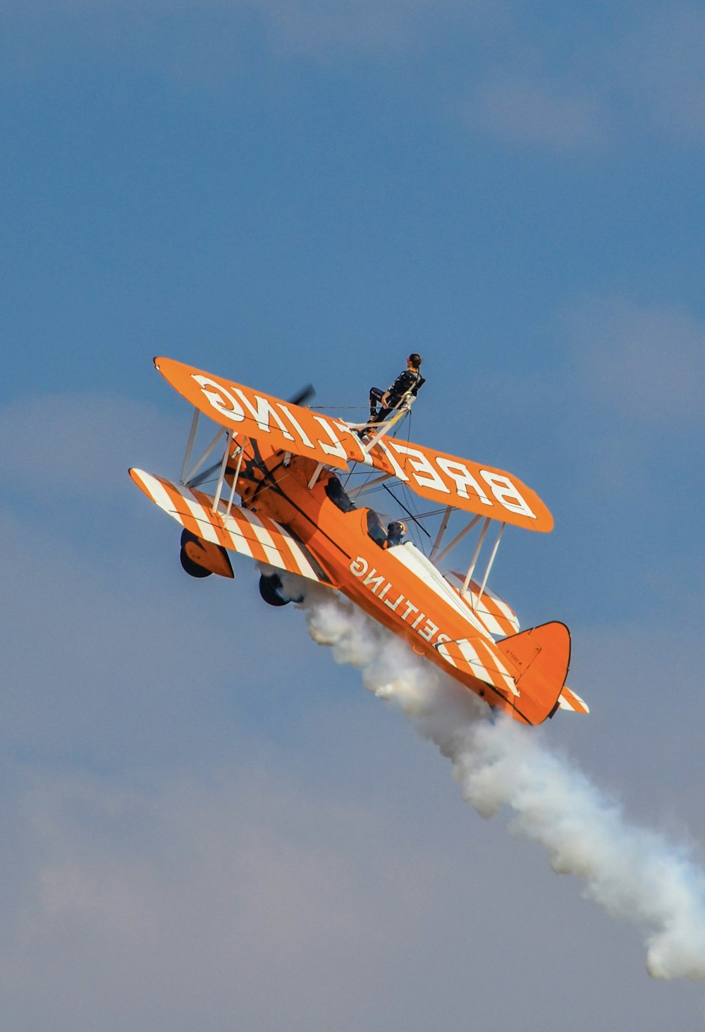 Avión naranja y amarillo volando en el cielo