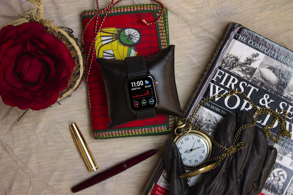 a couple of books and a watch on a bed