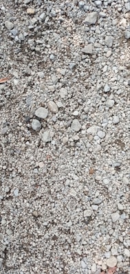Various sizes of gravel and sand aggregates displayed outdoors.