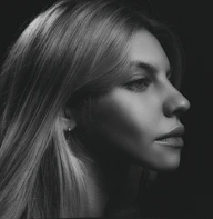 A striking black and white portrait emphasizing shadows and light contrast in a modern setting.