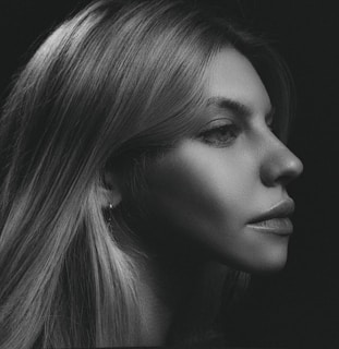 Black and white portrait of a model with sharp shadows highlighting facial features.