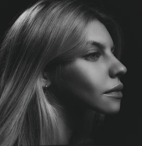 A striking black and white portrait emphasizing shadows and light contrast in a modern setting.