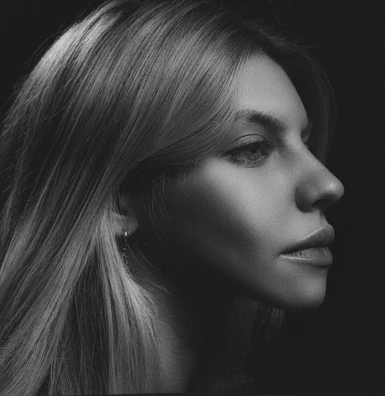 A black and white portrait with dramatic shadows.