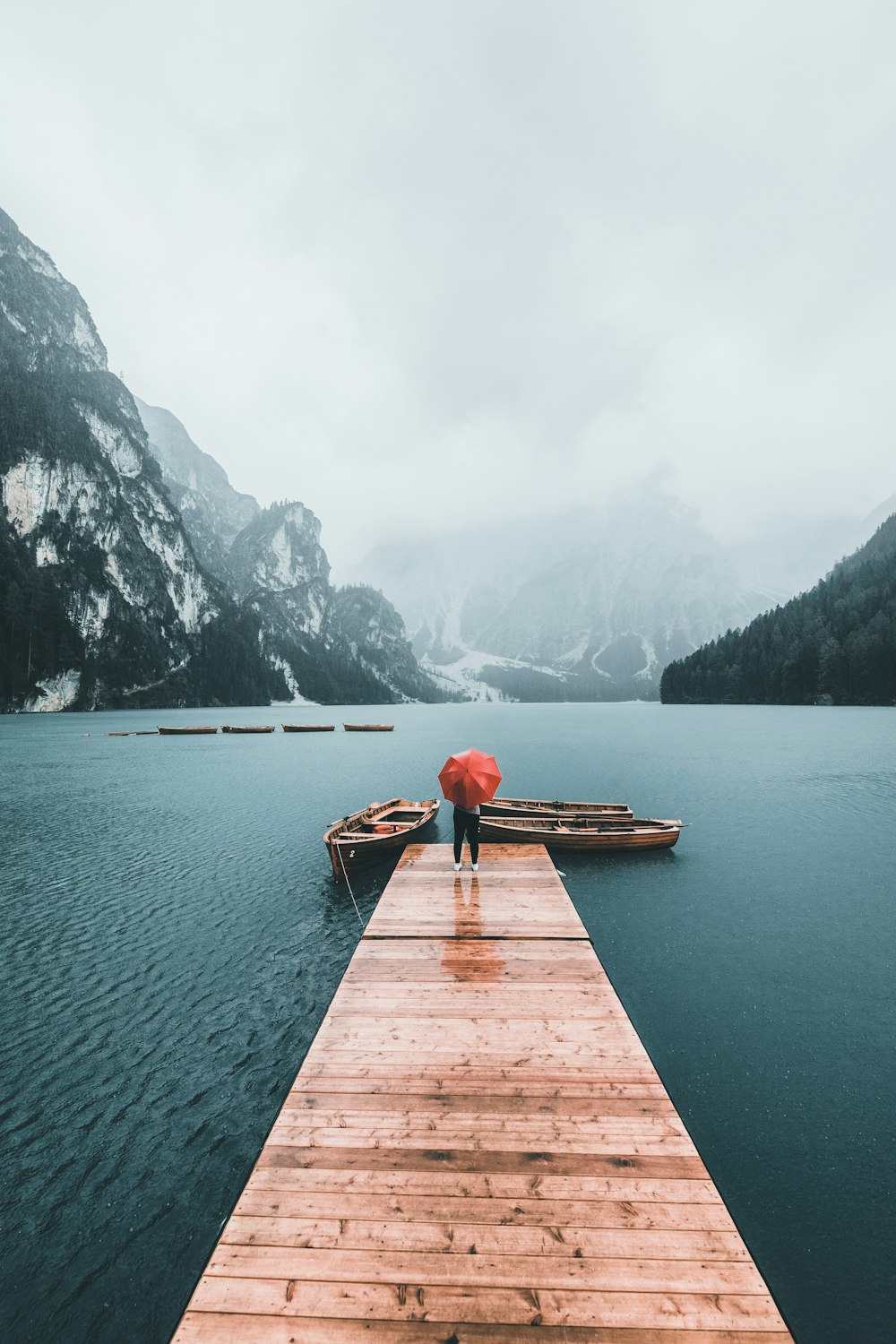 brown wooden dock on lake near mountain during daytime