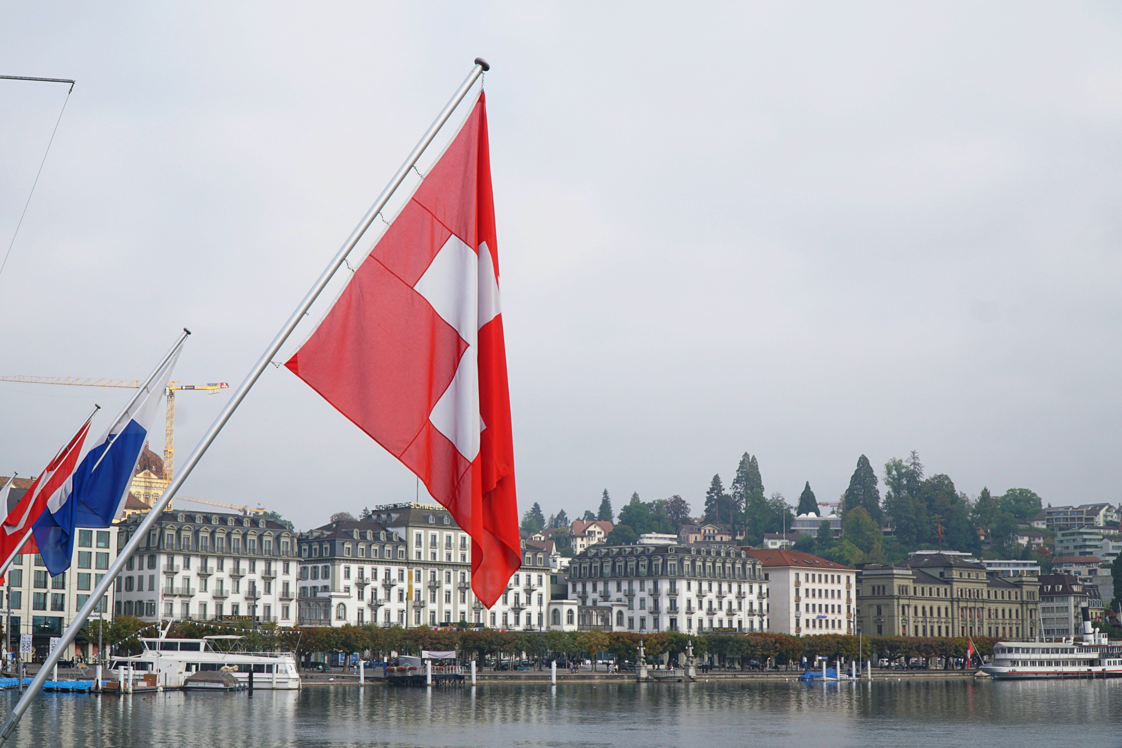 red and white flag on pole near body of water during daytime