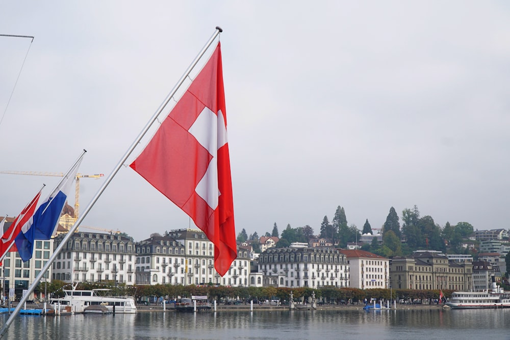 red and white flag on pole near body of water during daytime