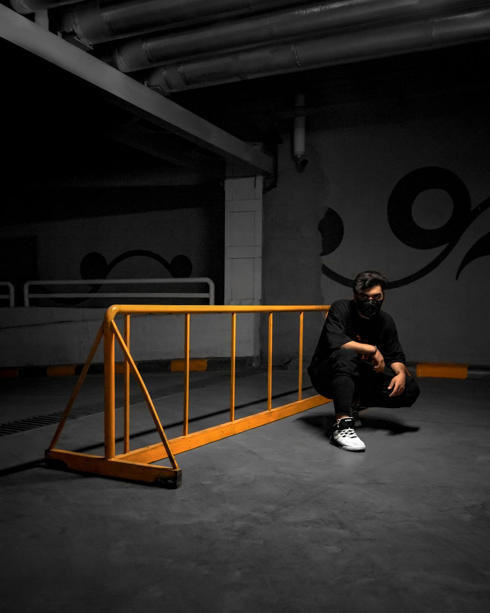 man in black jacket sitting on orange metal ladder