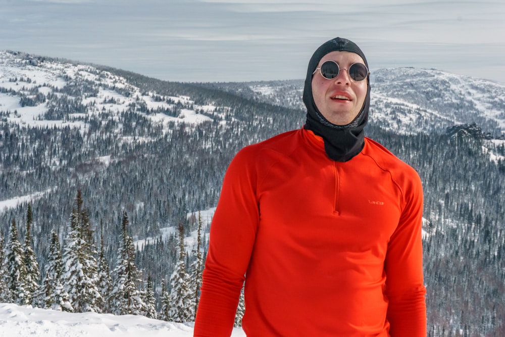 woman in red turtleneck sweater and black sunglasses standing on snow covered ground