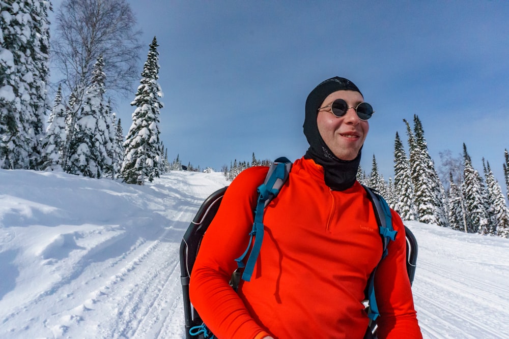 man in orange jacket wearing black sunglasses