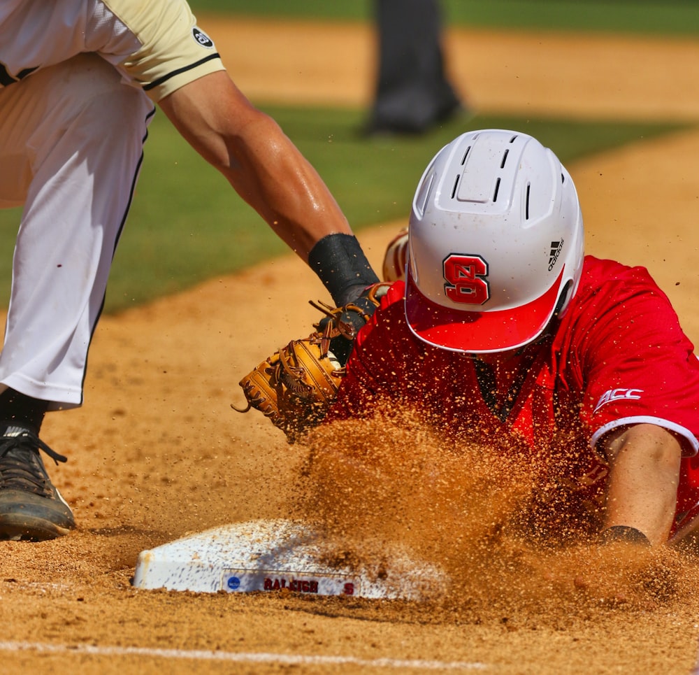 man in white and red jersey shirt and white pants playing baseball during daytime