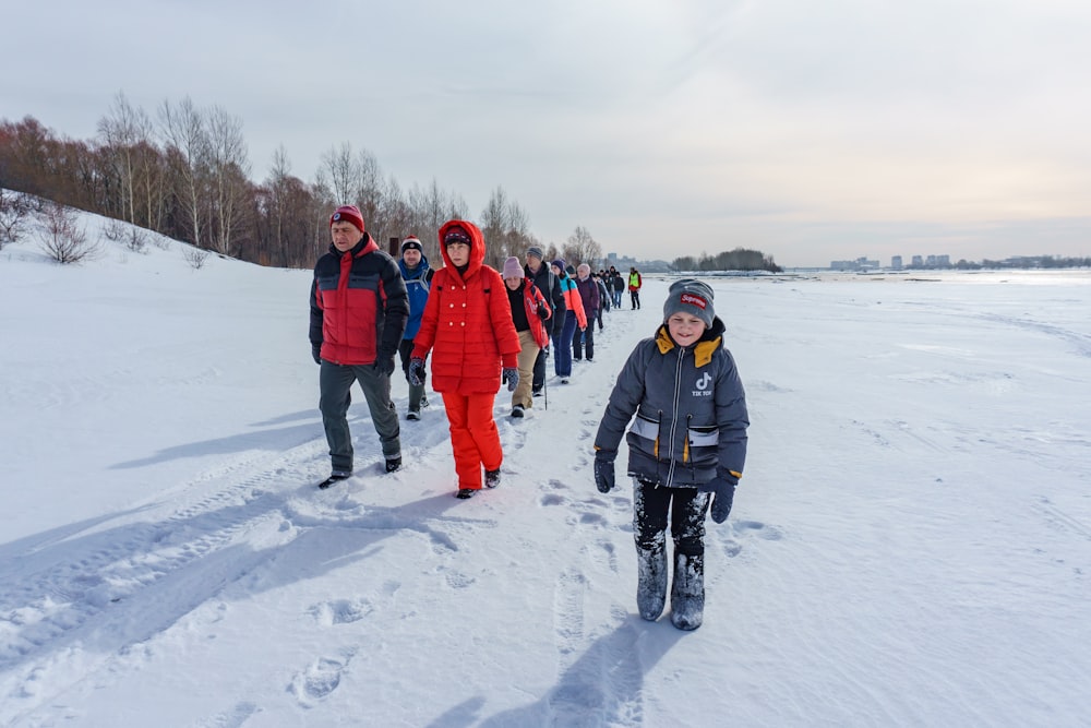 people in black jacket standing on snow covered ground during daytime